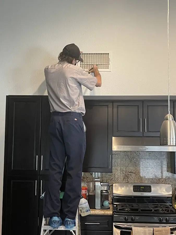 Technician inspecting an air vent during HVAC service in Levelland